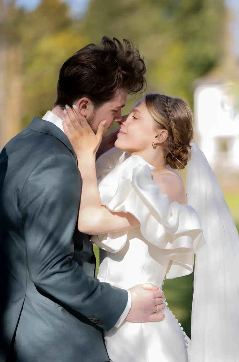 Hochzeitspaar umarmt sich liebevoll am Ufer.