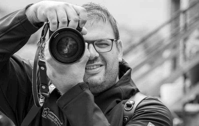 Hochzeitsfotograf Warburg Hochzeitsfotograf aus Warburg hält eine Kamera und lächelt.