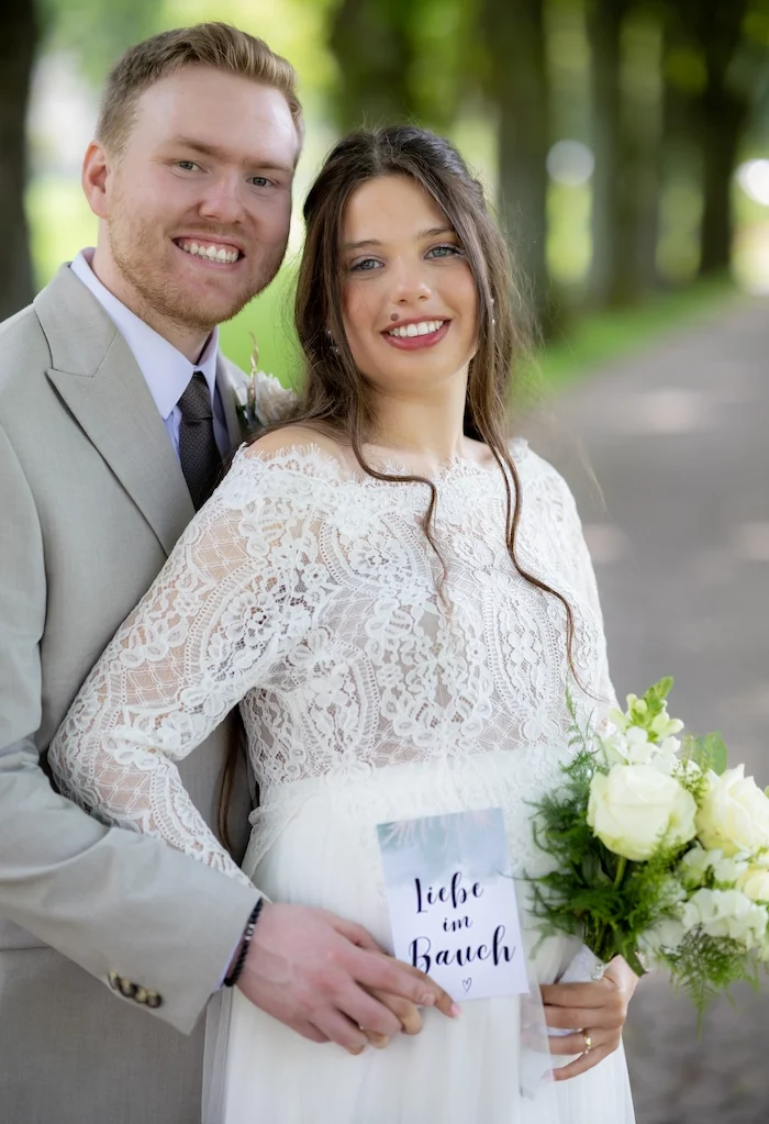 Hochzeitsfotos in Bad Driburg Brautpaar im Freien, die Braut hält einen Strauß und ein Schild mit "We said yes".