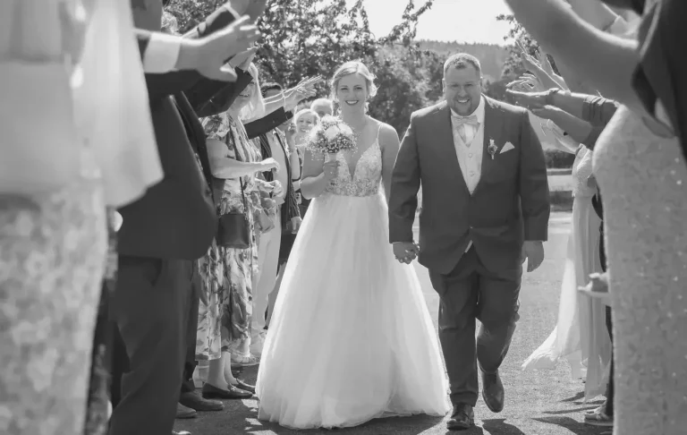 Hochzeitsfotograf Warburg Braut und Bräutigam lächeln sich auf einem Weg in warburg umgeben von Bäumen an.