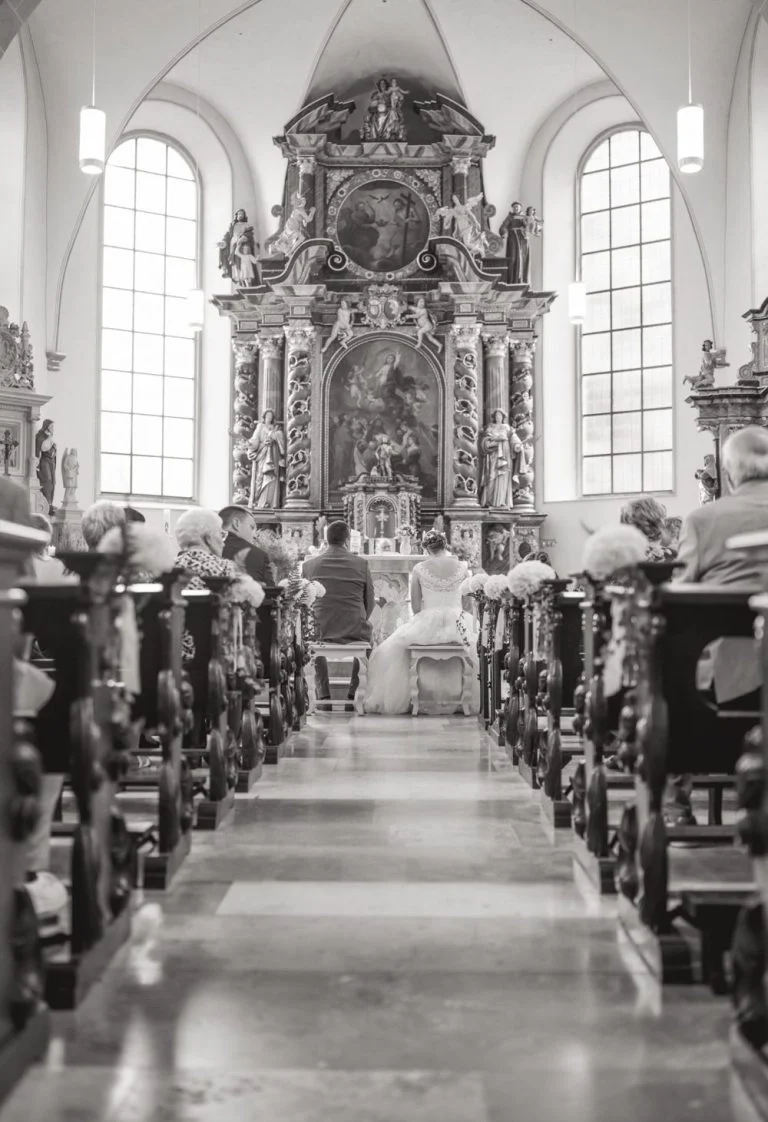 Kirchliche Hochzeit Bad Driburg Ein Blick auf den Altar einer Kirche mit ruhiger Atmosphäre und Holzbänken.