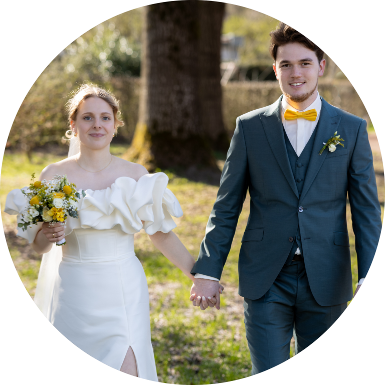 Brautpaar in eleganter Hochzeitskleidung, Hand in Hand im Freien.